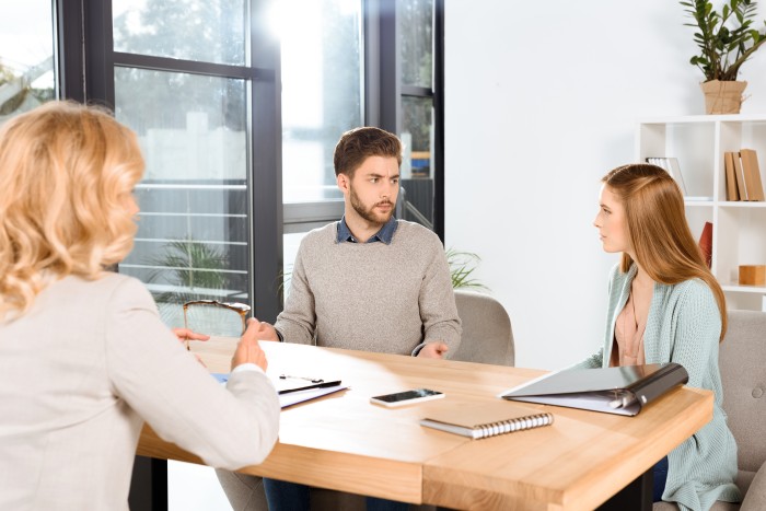 Serious couple looking at each other while speaking to a lawyer | Featured image of the Collaborative Practice Page of the Law People