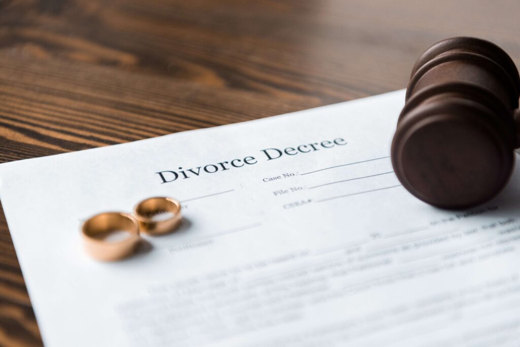 Close up view of divorce decree, wedding rings, and gavel in divorce lawyer meeting